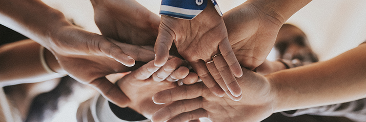 Group of diverse people stacking hands in the middle