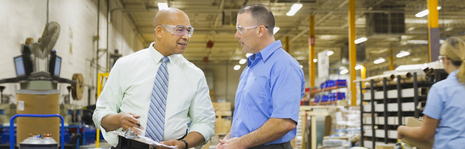 Two men discussing safety in a factory