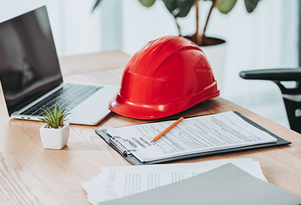 Hardhat and office supplies laying on office desk