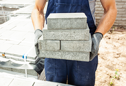 Stone worker carrying stone blocks