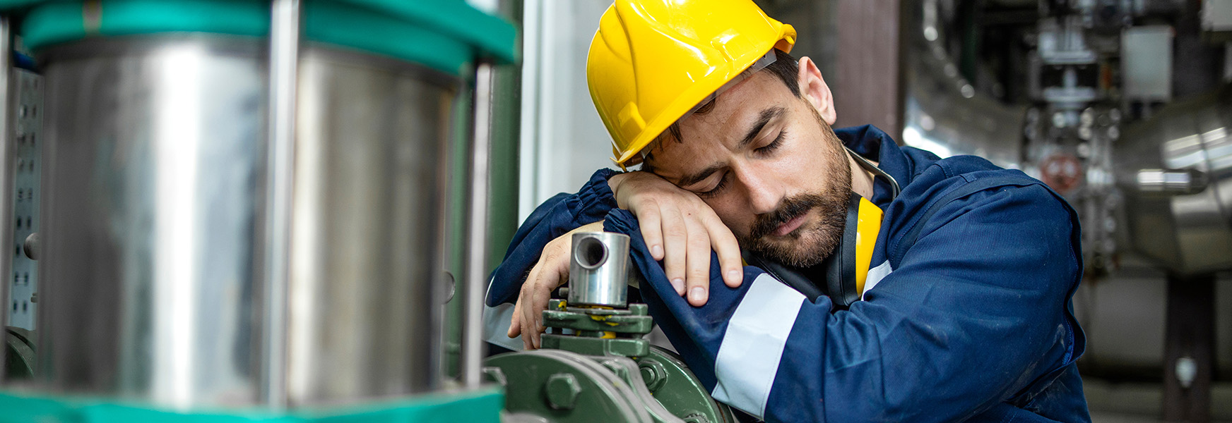 Tired factory worker sleeping on the job.
