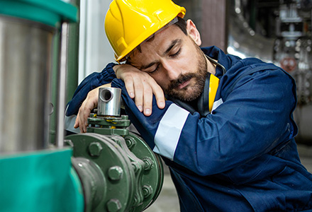 Tired factory worker sleeping on the job.