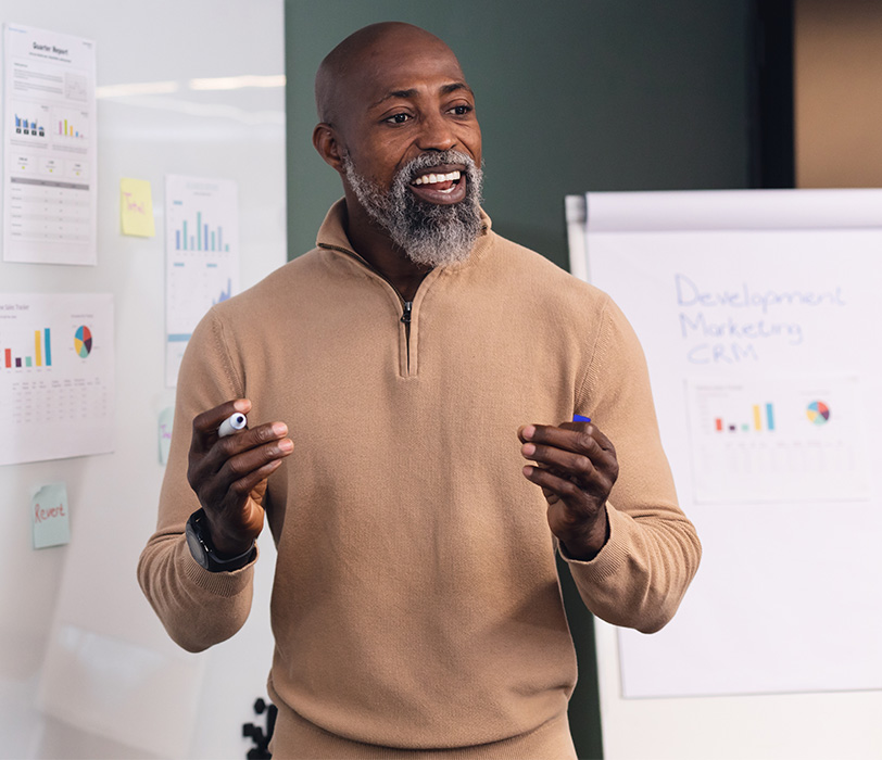 Enthusiastic mature business man presenting charts and data