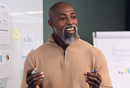 Enthusiastic mature business man presenting charts and data