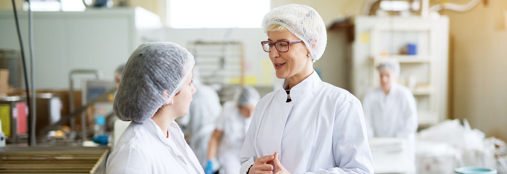 Female workers conversing in commercial kitchen