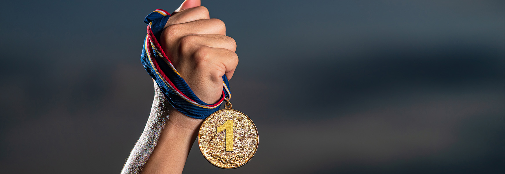 Hand grasping 1st place gold medal