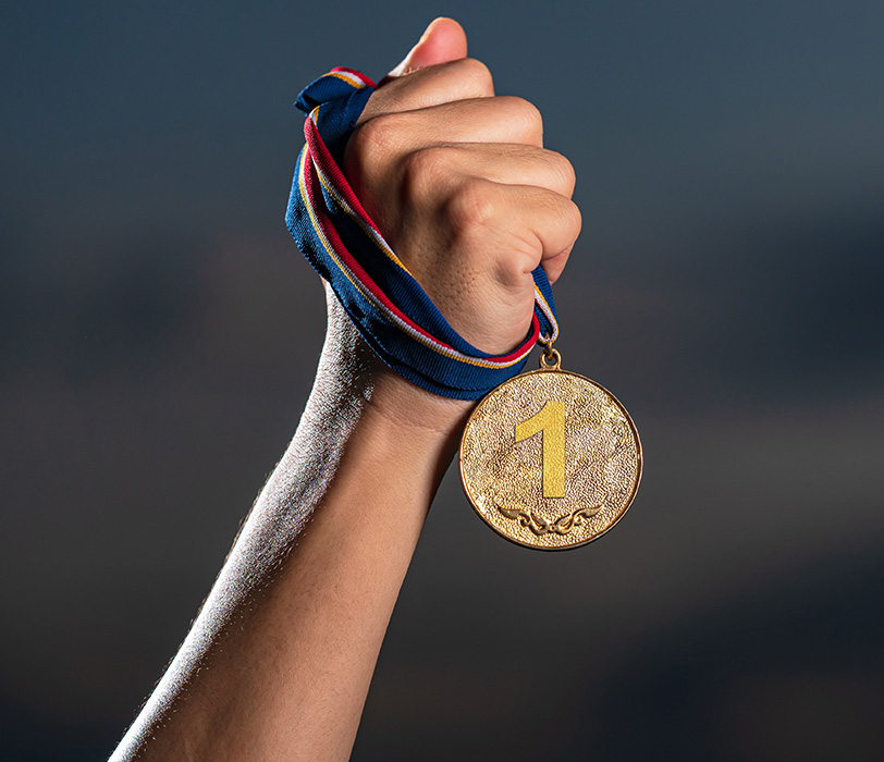 Hand grasping 1st place gold medal