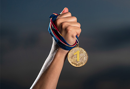 Hand grasping 1st place gold medal