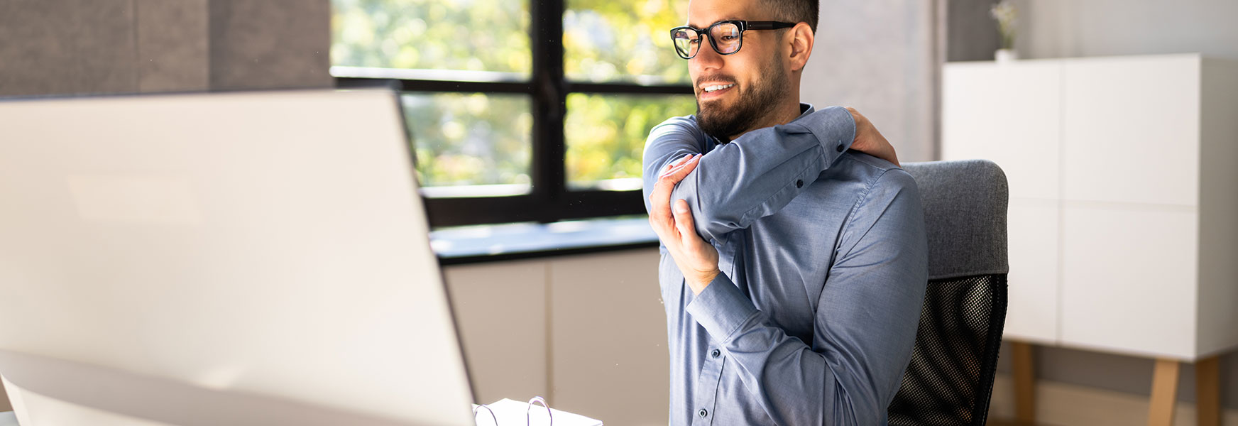 Young professional man sitting at computer workstation